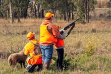 Youth hunter, hunting dog, and mentor together in the field at the 2025 Youth Mentor Hunt