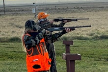 Youth hunter at an outdoor shooting range with a harvested pheasant at the 2025 Youth Mentor Hunt